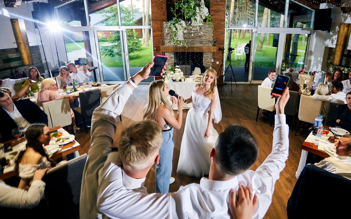 Recepție de nuntă în interior, cu invitați care dansează